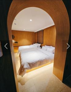 a bedroom with a large white bed with an archway at 인천청라점 이상한스테이 