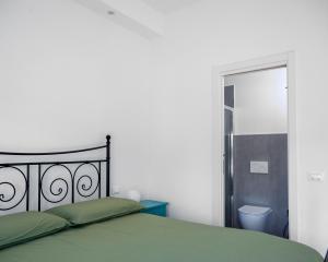 een slaapkamer met een groen bed en een badkamer bij Camera Matrimoniale con bagno privato-struttura condivisa con Host-CASA ENEA in Florence