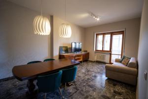 a living room with a table and chairs and a couch at Appartamento con vista città - SmartCheck-In & Wifi Fibra in Campobasso