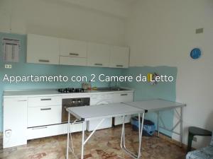 a white kitchen with a table and a counter at Suite 7 in Paglieta