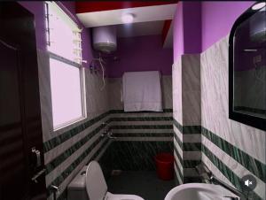 a bathroom with a toilet and a sink and a window at Tashidelk homestay in Darjeeling +4 photos