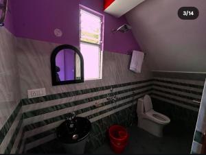 a purple bathroom with a toilet and a sink at Tashidelk homestay in Darjeeling
