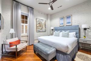 a bedroom with a large bed and a chair at Perfect Location - King Street Condo in Charleston