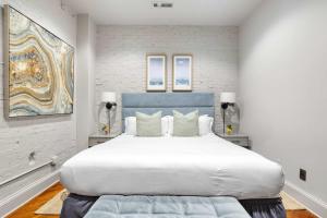 a bedroom with a large white bed with pillows at Perfect Location - King Street Condo in Charleston