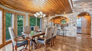 a dining room with a table and a stone wall at The Royal Chateau-5BED6BATHPoolHottub-20PP in Osage Beach