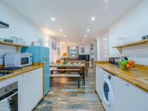 een keuken met blauwe apparatuur en een eetkamer bij 4 Bed in Seascale oc-85807 in Gosforth