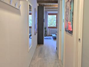 a hallway with white walls and wood floors and paintings at Moda Apartments 47 in Sestriere +6 photos