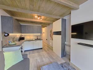 a kitchen and living room with white cabinets at Moda Apartments 47 in Sestriere