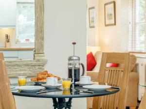 einen Glastisch mit Essen und Orangensaft darauf. in der Unterkunft The Bothy in Mathon