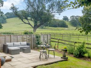 eine Terrasse mit einem Sofa und einem Tisch und Stühlen in der Unterkunft The Bothy in Mathon