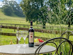 eine Flasche Wein mit zwei Gläsern auf einem Tisch in der Unterkunft The Bothy in Mathon + 16 Fotos