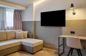 a hotel room with a couch and a desk at Casa Serras Andorra in Andorra la Vella