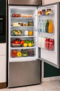 een open koelkast gevuld met veel groenten en fruit bij Green Plants 24 7 Check In 4 Persons in Kelkheim