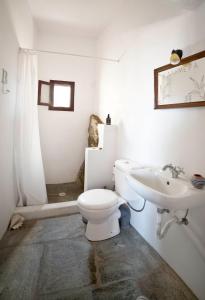 een witte badkamer met een toilet en een wastafel bij Liotrivi, traditional house in Apollonia