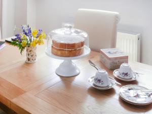 a cake in a glass dome on a table at Silver Birch Lodge in Horsley
