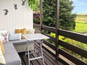 a porch with a bench and a table and a view at Harperfield Chalet in Lanark +23 photos