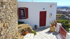 een wit gebouw met rode deuren en potplanten bij Liotrivi, traditional house in Apollonia +32 foto's