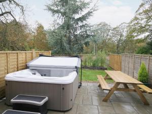 een hottub en een picknicktafel in een achtertuin bij Granary Cottage - E5626 in Wainfleet All Saints +1 foto