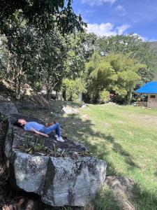 a woman laying on a rock in a park at Suelo Vivo Eco Hotel in Bochalema