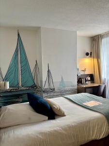 una camera con un letto con due barche a vela sul muro di Ambassadeur Hotel - Cherbourg Port de Plaisance a Cherbourg en Cotentin