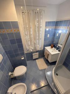 a blue tiled bathroom with a toilet and a sink at HENRY BENNEt in Menton +21 photos