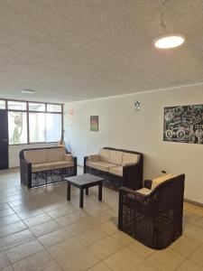 een woonkamer met 3 banken en een tafel bij Charlotte House in Huanchaco