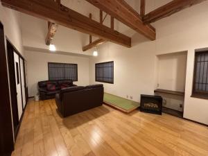 een woonkamer met een bank en een open haard bij Fuji-Kurohime- in Shinano