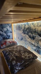 ein Bett mit einem schneebedeckten Bild an der Wand in der Unterkunft Le Flocon, Joli Cocon 4 pers avec Cheminée, LES ROUSSES, Draps inclus & Parking gratuit in Les Rousses + 34 Fotos