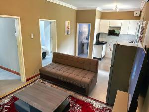 a living room with a couch and a kitchen at Zengu in Lusaka
