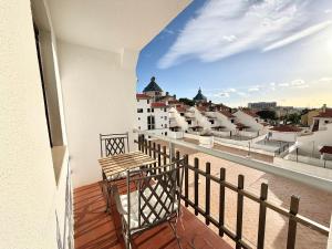 a balcony with a wooden table and a view of a city at Algardia Marina Parque by Garvetur in Vilamoura