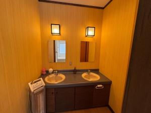 een badkamer met twee wastafels en een spiegel bij Fuji-Kurohime- in Shinano +35 foto's