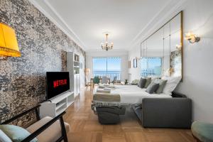 a bedroom with a bed and a tv on a wall at Le COQ Livieri - AC- WiFi - Seafront - town centre in Menton