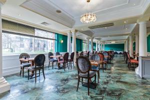 a dining room with tables and chairs and a chandelier at Winchester Wessex Hotel by Sunday in Winchester