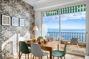 a dining room with a table and chairs and a view of the ocean at Le COQ Livieri - AC- WiFi - Seafront - town centre in Menton