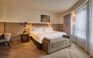 a hotel room with a bed and a chair at Casa Serras Andorra in Andorra la Vella