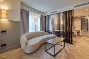 a living room with a white chair and a table at Casa Serras Andorra in Andorra la Vella