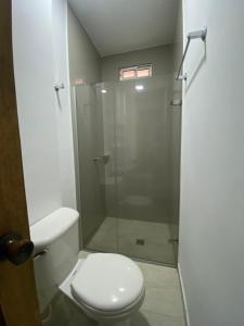 een badkamer met toilet en glazen douche bij HOTEL NES in Maicao +21 foto's