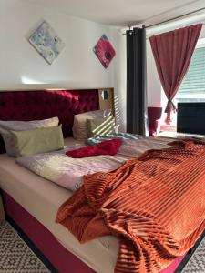 een bed met een oranje deken erop in een slaapkamer bij MemmingenBuxheimKartause in Buxheim