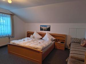 a bedroom with a large bed and a window at Gästehaus Finkel in Maderhalm