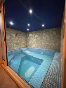 a jacuzzi tub in a room with a stone wall at Meithras Holiday Homes in Agrigento