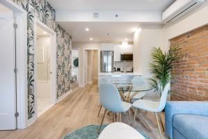 ein Wohnzimmer mit einer Ziegelwand und einem Glastisch und Stühlen in der Unterkunft Mont Royal Suites - M11 in Montreal