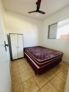 een slaapkamer met een bed en een plafondventilator bij Pousada Emanuel in Araranguá