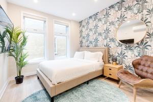 ein Schlafzimmer mit einem Bett, einem Spiegel und einem Stuhl in der Unterkunft Mont Royal Suites - M11 in Montreal