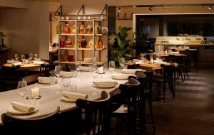 een eetkamer met tafels en stoelen, witte borden en servetten bij Casa Serras Andorra in Andorra la Vella