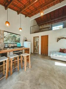 una cucina con un tavolo e sedie in una stanza di Girassóis do Vale - Chalés no Vale do Capão a Caeté-Açu