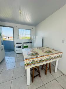 een keuken met een tafel en een aanrechtblad bij Pousada Emanuel in Araranguá