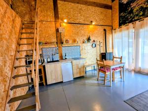 a room with a staircase and a table and a kitchen at la caseta viva in Olvan