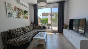 a living room with a couch and a flat screen tv at Brisa Apartment in Burgas City