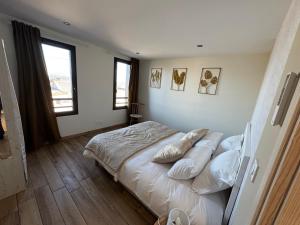 a bedroom with a bed with pillows on it at Lodges des Pontons - Cap Est - vue mer in Saint-Côme-de-Fresné