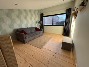 a living room with a couch and a window at Lodges des Pontons - Cap Est - vue mer in Saint-Côme-de-Fresné